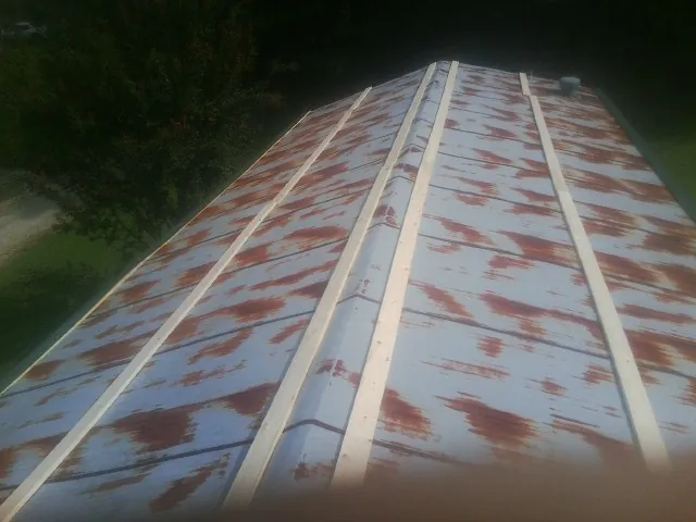 Rusted metal roof panels with new wood purlins before replacement — Storm Damage Roof Repair in Natchez by Roofing Brothers